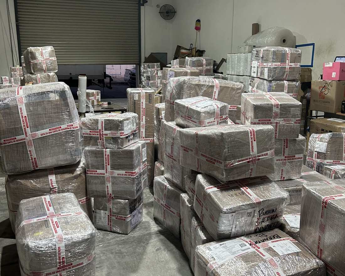 Paquetes de clientes envueltos con plástico y cinta de seguridad roja en la bodega de Compras en USA en Laredo, Texas